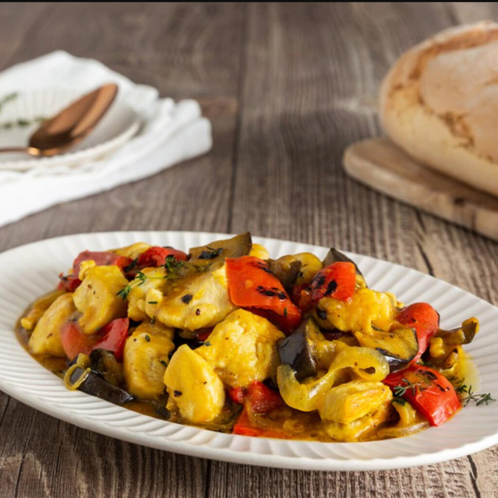 Pollo allo zafferano con verdure grigliate servito nel piatto