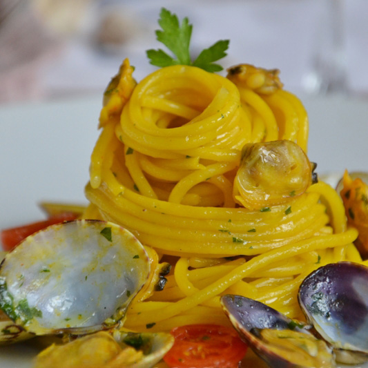 Spaghetti con vongole e zafferano serviti nel piatto